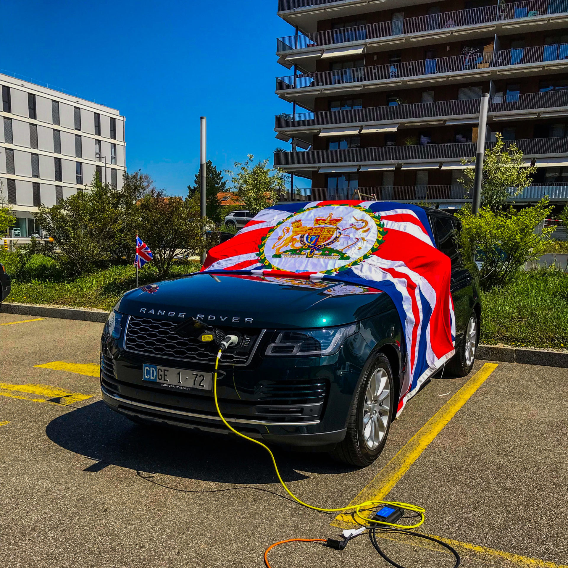 Electric Range rover parked in car park attached to charging cable