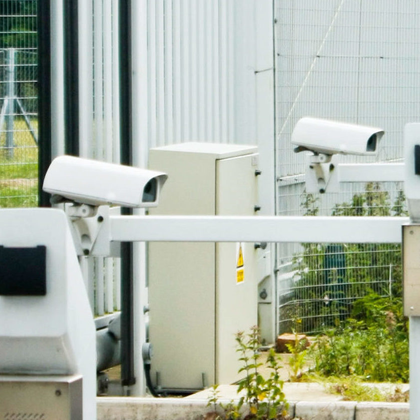 CCTV cameras at a secure gate on a perimeter fence.
