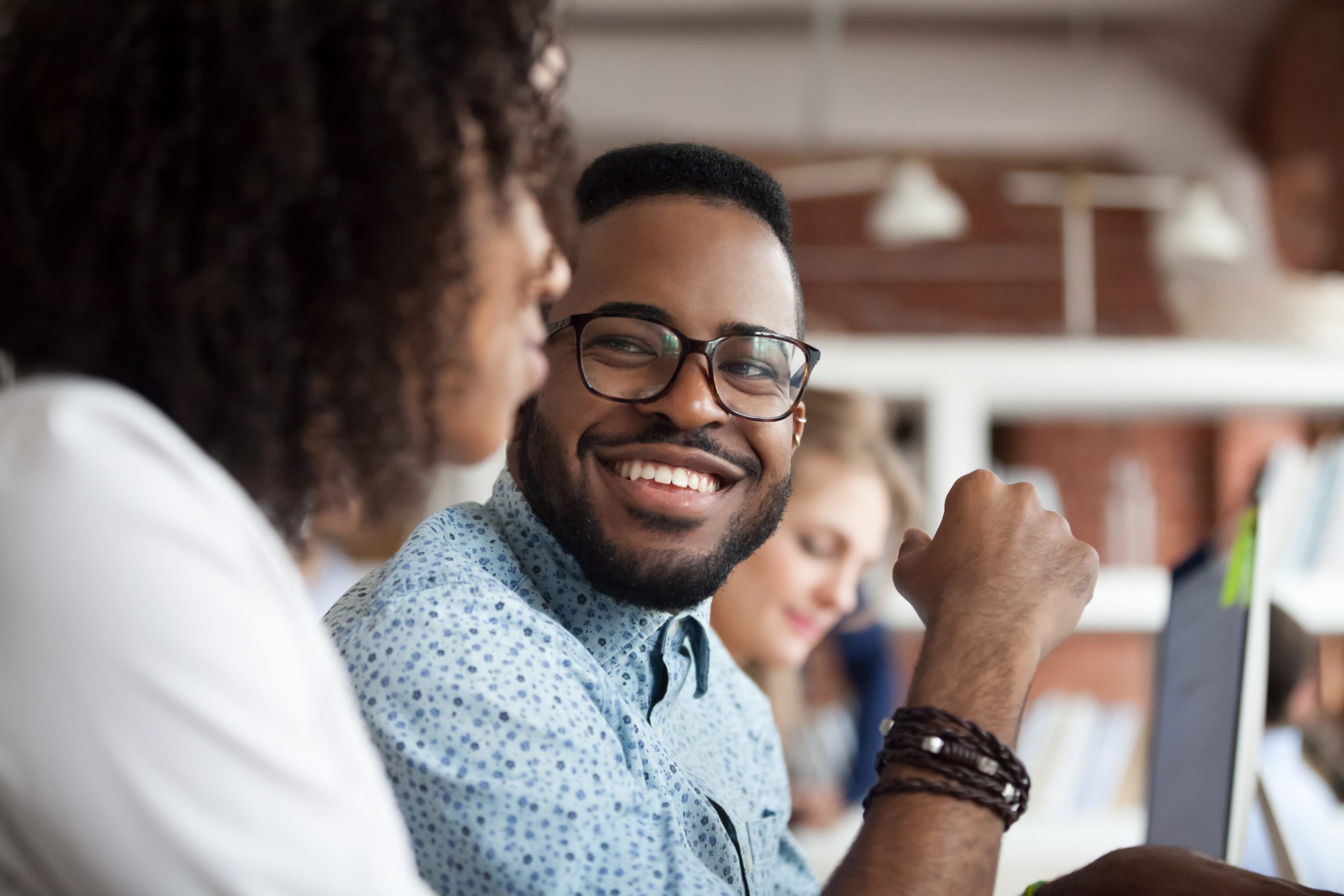 man with glasses smiling at colleague