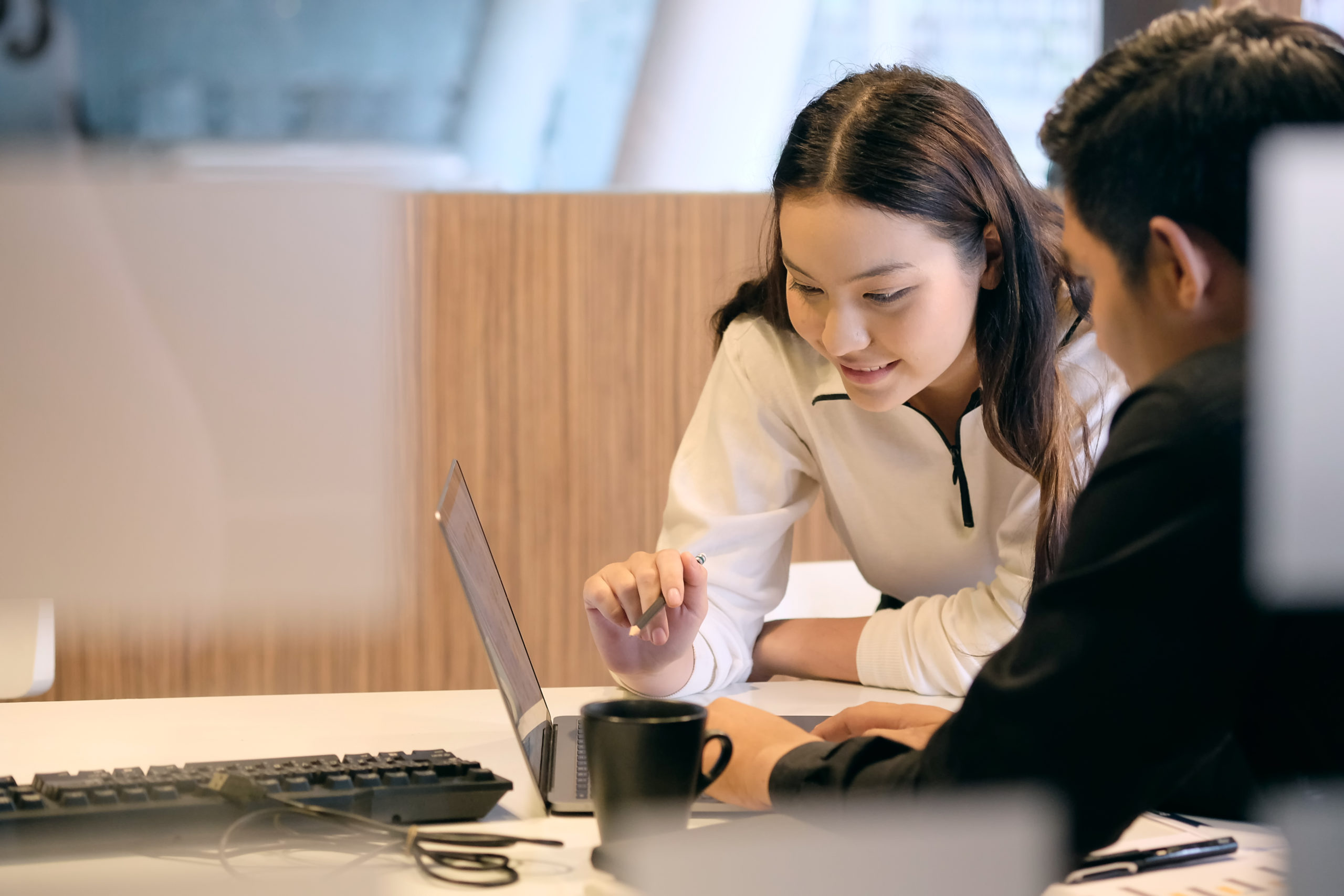 woman and man in office looking at laptop